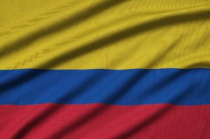 Colombia flag is depicted on a sports cloth fabric with many folds. Sport team waving banner