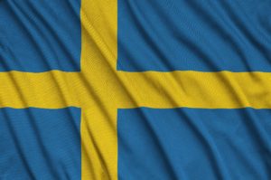 Sweden flag is depicted on a sports cloth fabric with many folds. Sport team waving banner